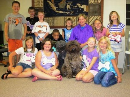 group of kids posing with dog