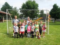 kids taking picture in front of soccer goal