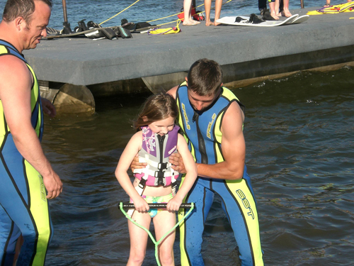 man helping girl water ski