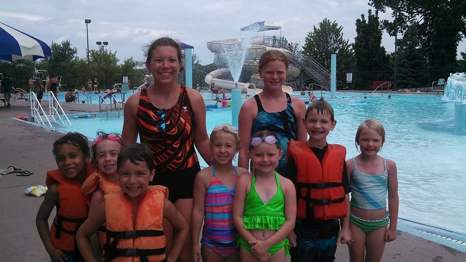 group of kids with swimming instructors